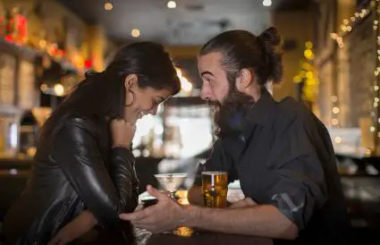 Couple parlant à table avec cocktail et bière 